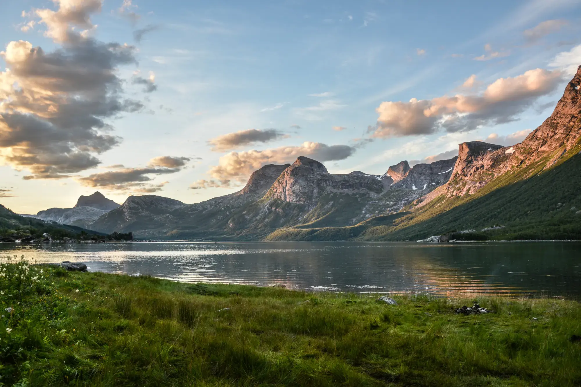 Fjord med fjellrekke i kveldslys