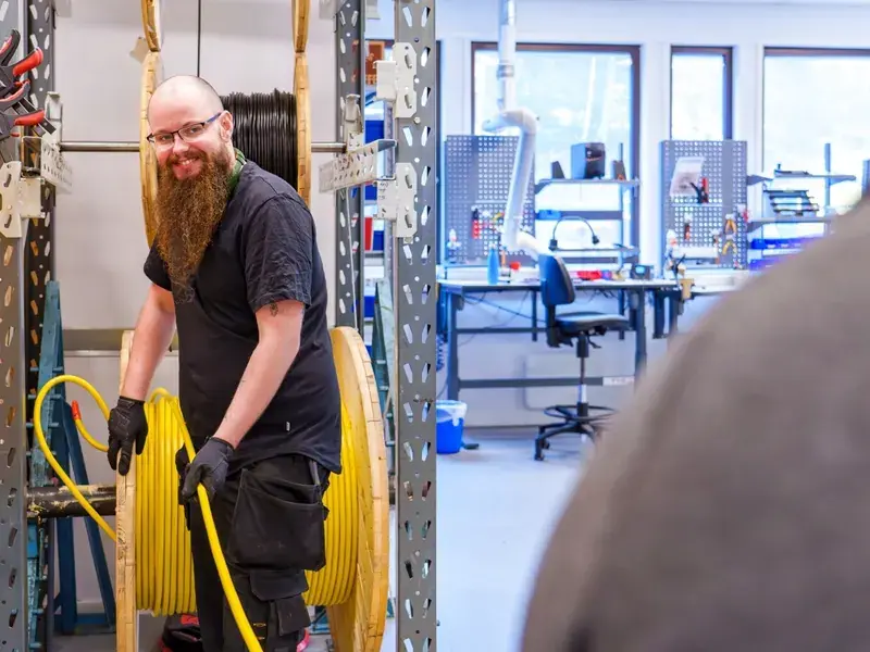 Lars med kabeltrommel i produksjonslokalet